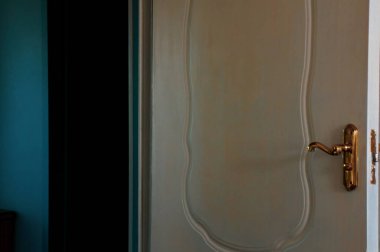 Koridora bakan altın saplı beyaz kapıyı aç.