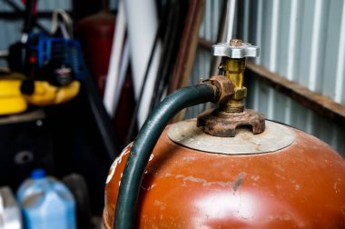 Kırmızı gaz tüpü garajda ya da dolapta duruyor. Vanayı ve hortumu kapat.