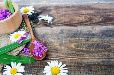 Tahta bir rustik masada çiçek ve papatya çayı, Epilobium angustifolium. Fireweed (Rosebay Willowhere), tahta kaşıkta pembe çiçekler, şifalı otlar, kopyalama alanı