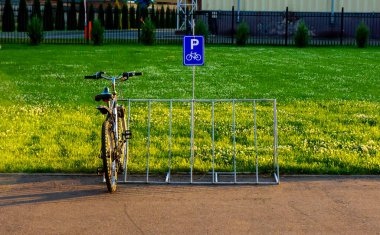 Park arka planında bisiklet ve bisiklet park levhası