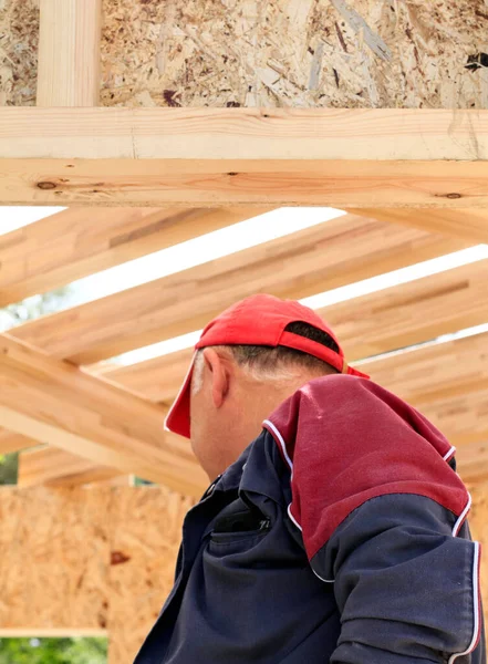 Worker in building site with wooden structure