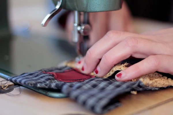 Sewing with machine. Detail of tailor hand working with fabric