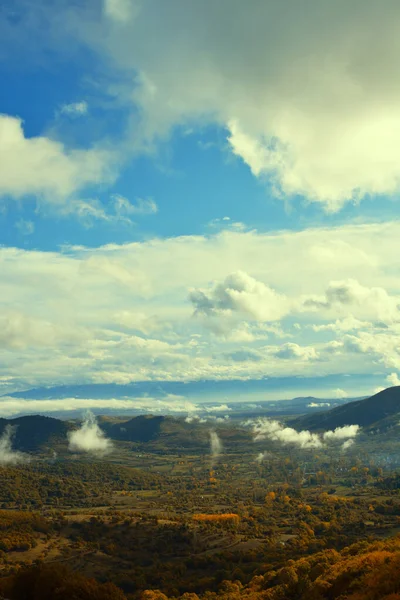 Sonbahar sabahı sis kalıntılarıyla vadideki kırsal manzara.