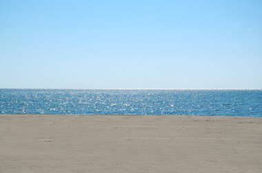 Arka plan olarak gökyüzü, deniz ve kum
