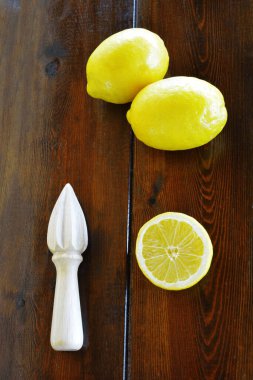 Cilalanmamış limon, yarım limon ve limon sıkacağı.