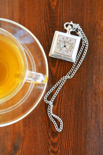 Cup of tea and antique pocket watch