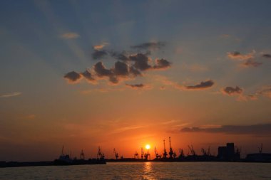 Gün batımında vinç siluetleri