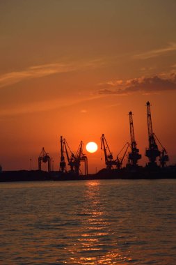 Gün batımında vinç siluetleri