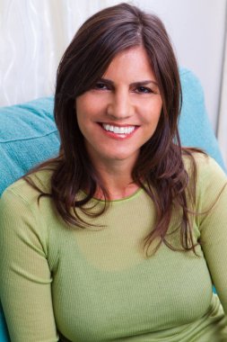 Mutlu kadın kanepede oturan gülümseyen.