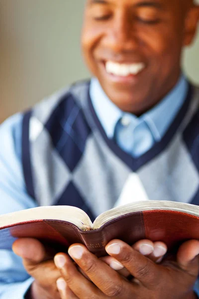 African American man sitting on a sofa reading. — Stock Photo, Image