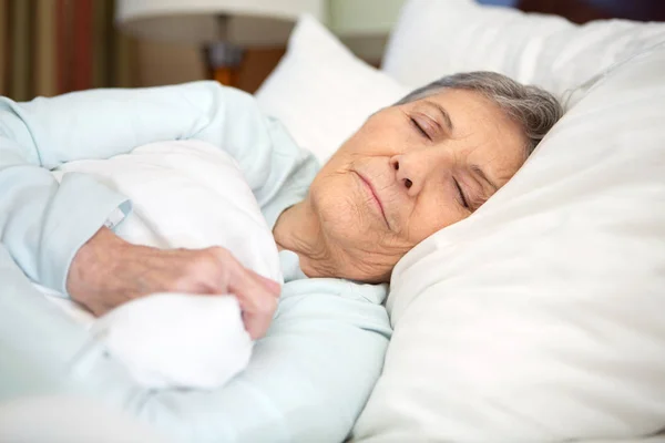 Elderly woman getting a good nights rest. — Stock Photo, Image