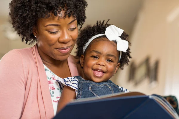 Mutter liest ihrem kleinen Mädchen ein Buch vor. — Stockfoto