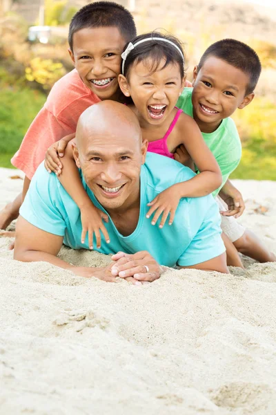 Apa, játszik a gyerekeit a tengerparton. — Stock Fotó