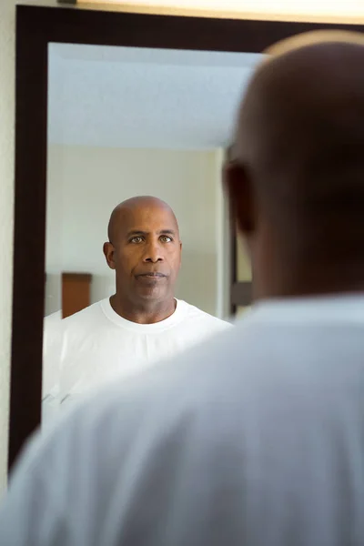 African American man in de spiegel kijken. — Stockfoto