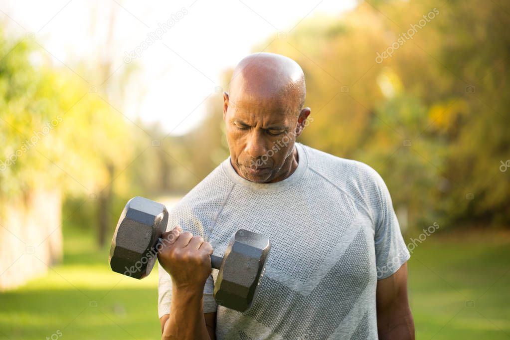 Fit African American man lifting weights