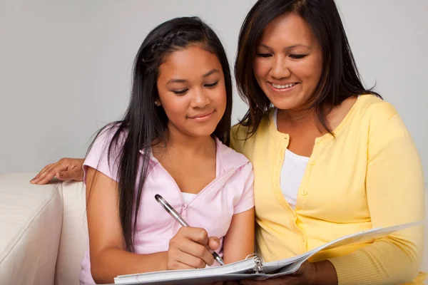 Mãe ajudando sua filha com lição de casa . — Fotografia de Stock