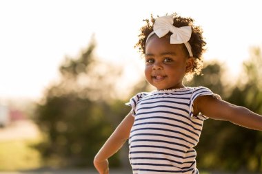 Gülüyor ve dışarıda gülümseyen mutlu küçük kız.