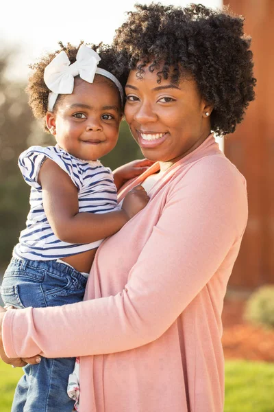 Madre afroamericana sosteniendo a su hija . — Foto de Stock