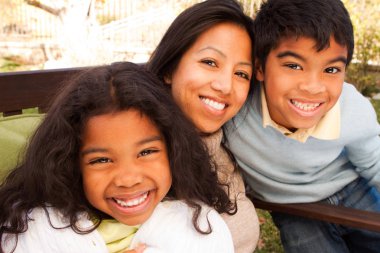 Biracial aile gülüyor ve dışarıda gülümseyen.