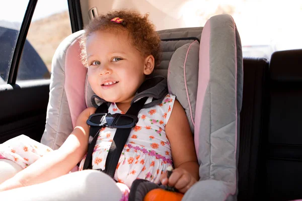 Menina sorrindo em seu assento de carro . — Fotografia de Stock