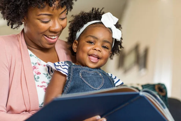 Mutter liest ihrem kleinen Mädchen ein Buch vor. — Stockfoto