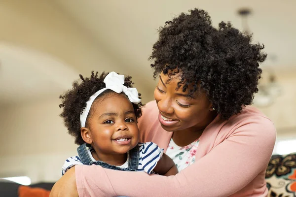 Afro-Amerikaanse familie. Moeder en dochter lachend thuis. — Stockfoto