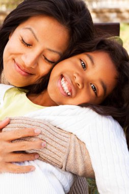 Biracial anne ve gülüyor ve dışarıda gülümseyen kız.