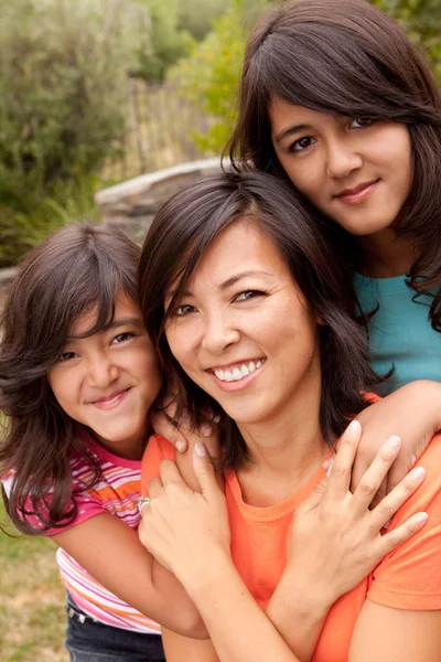 Asian mother and her daughters hugging and laughing. — Stock Photo, Image