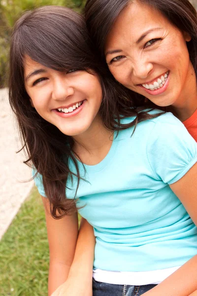 Aziatische moeder en haar dochters knuffelen en lachen. — Stockfoto