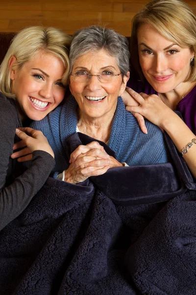 Familie van drie generatie vrouwen knuffelen en glimlachen. — Stockfoto