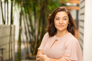 Gülümseyen ve ayakta dışında mutlu Hispnaic kadın.