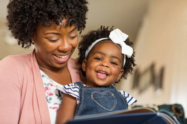 Mutter liest ihrem kleinen Mädchen ein Buch vor. — Stockfoto