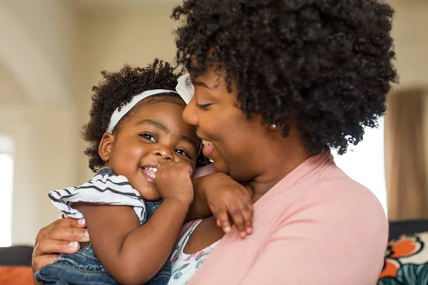 Afro-Amerikaanse familie. Moeder en dochter lachend thuis. — Stockfoto