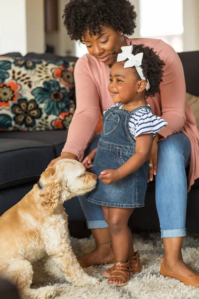 Niña y su mamá jugando con su perro . — Foto de Stock