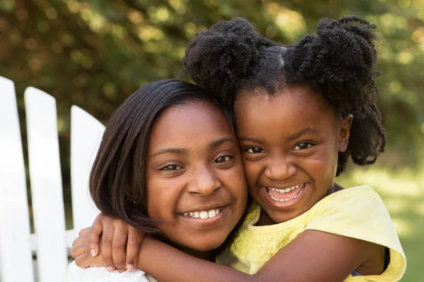 Retrato de dos hermanas afroamericanas abrazándose afuera . — Foto de Stock