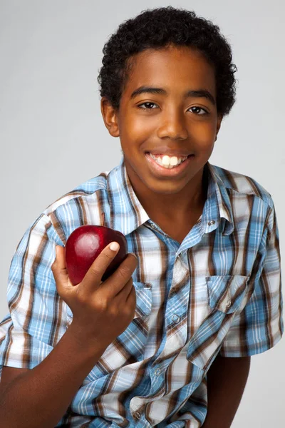 Ung African American kid äta ett äpple som isolerad på vit. — Stockfoto