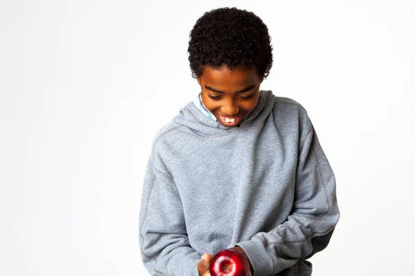 Joven niño afroamericano comiendo una manzana aislada en blanco . — Foto de Stock