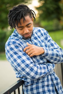 Dışarıda gülümseyen genç Afro-Amerikan yakışıklı.