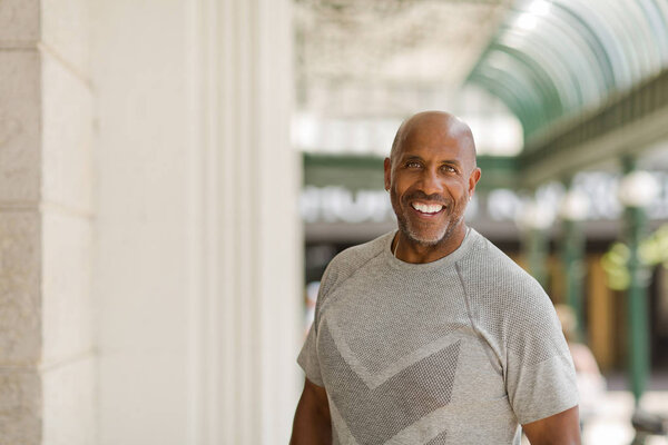 Happy mature African American man smiling outside.