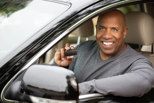 African American man driving a new car