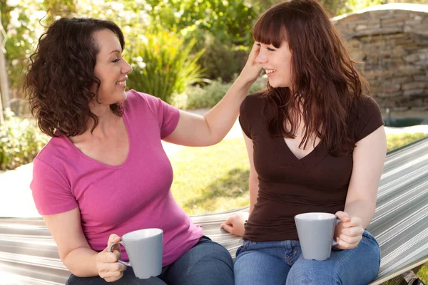 Mother and teenage daughter talking and drinking tea. — Stock Photo, Image