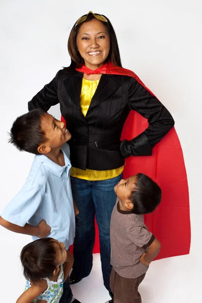 Super herói mãe com seus filhos segurando mantimentos . — Fotografia de Stock