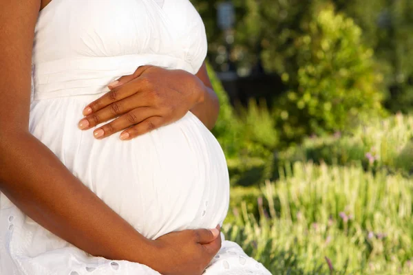Mladý Američan Afričana těhotná žena držící ji žaludek. — Stock fotografie