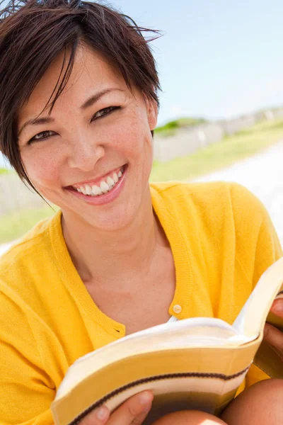 Donna asiatica che sorride e legge la Bibbia sulla spiaggia — Foto Stock