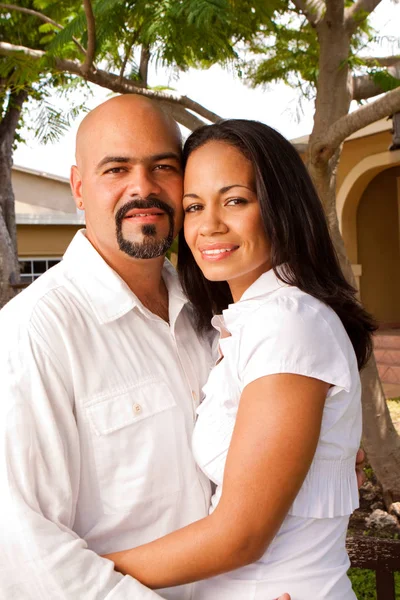 Happy Hispanic couple laughing and smiling outside.