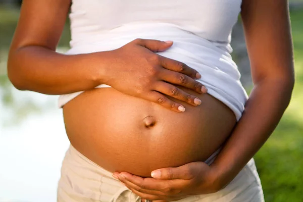 Νέοι Αφρικανικός Αμερικανός κρατώντας το στομάχι της εγκύου γυναίκας. — Φωτογραφία Αρχείου