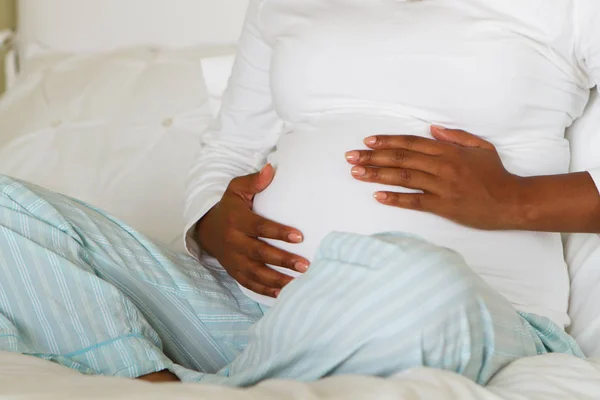 Joven mujer embarazada afroamericana sosteniendo su estómago . —  Fotos de Stock