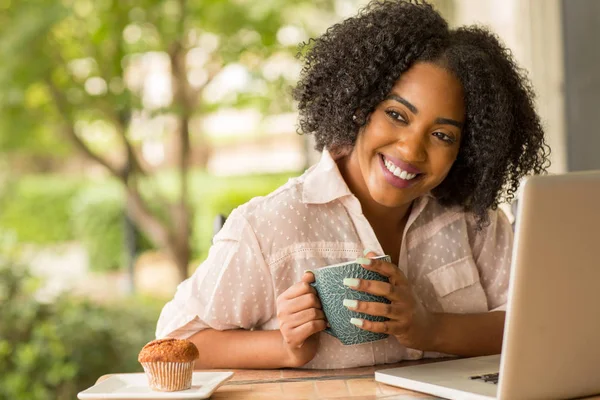 Mulher afro-americana trabalhando e bebendo café . — Fotografia de Stock