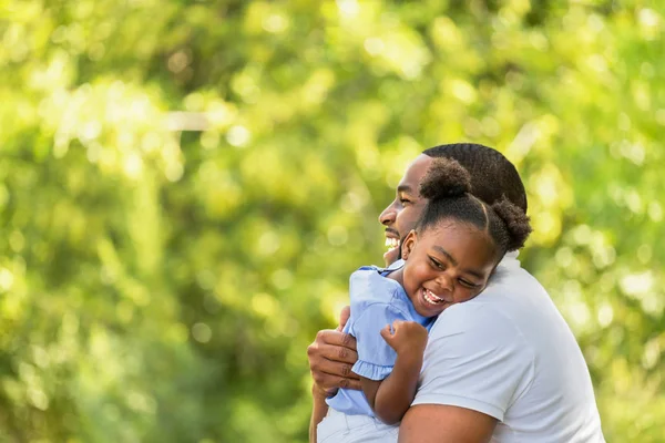 Afro-americano pai abraçando e segurando sua menina . — Fotografia de Stock