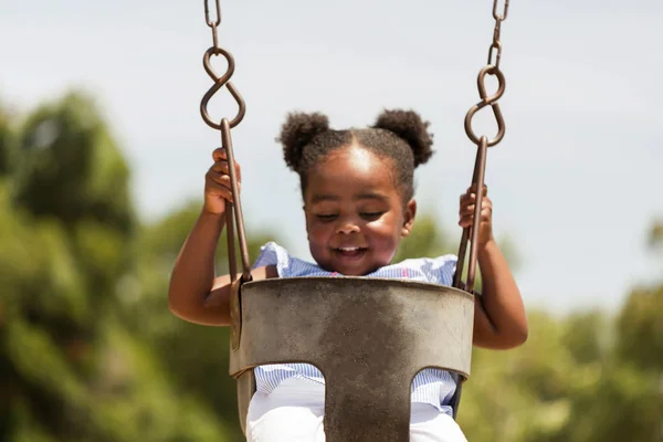 Cute little African American kołysanie w parku. — Zdjęcie stockowe